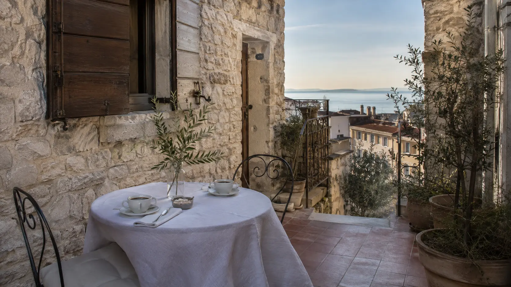 Corte in pietra di Casa Lume affacciata sui tetti e sul Golfo di Trieste